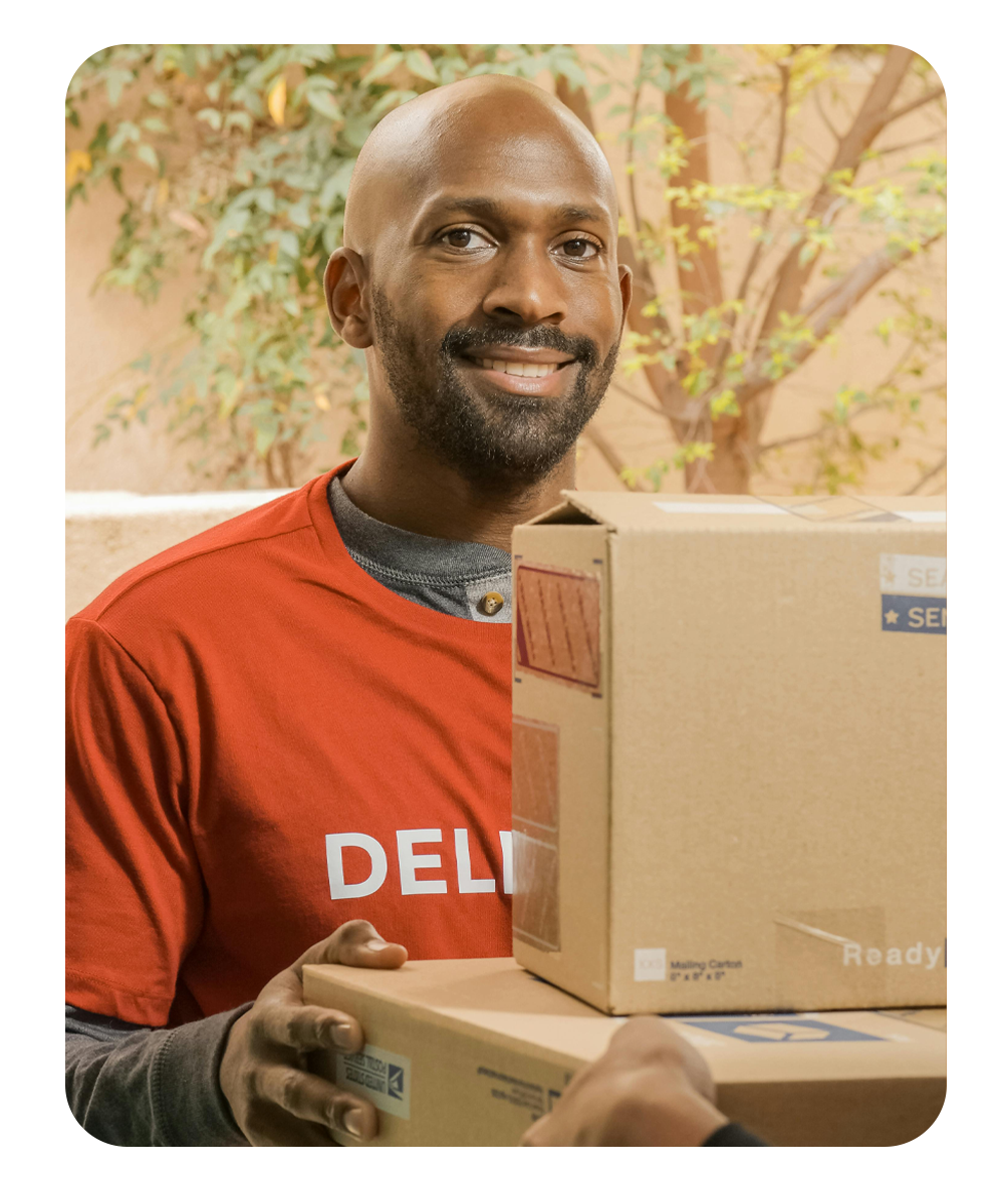 Professional medical courier driver smiling while holding secure delivery boxes for Atlanta Medical Courier Services.